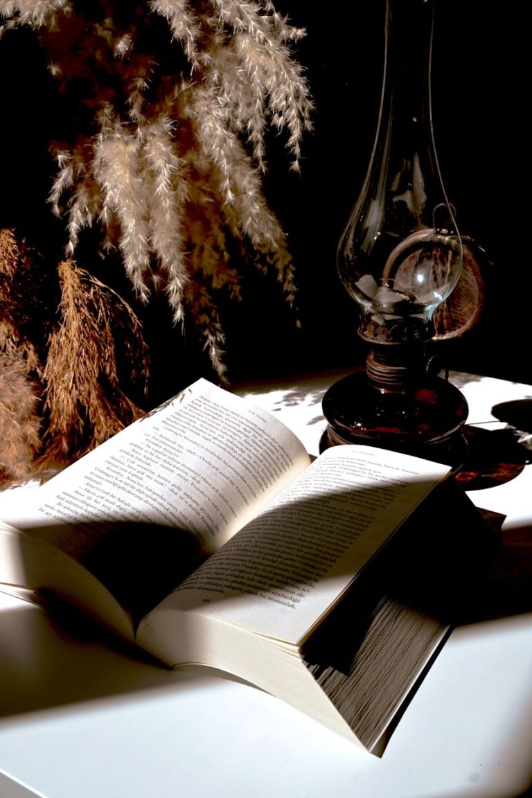 vintage book and oil lamp on rustic table