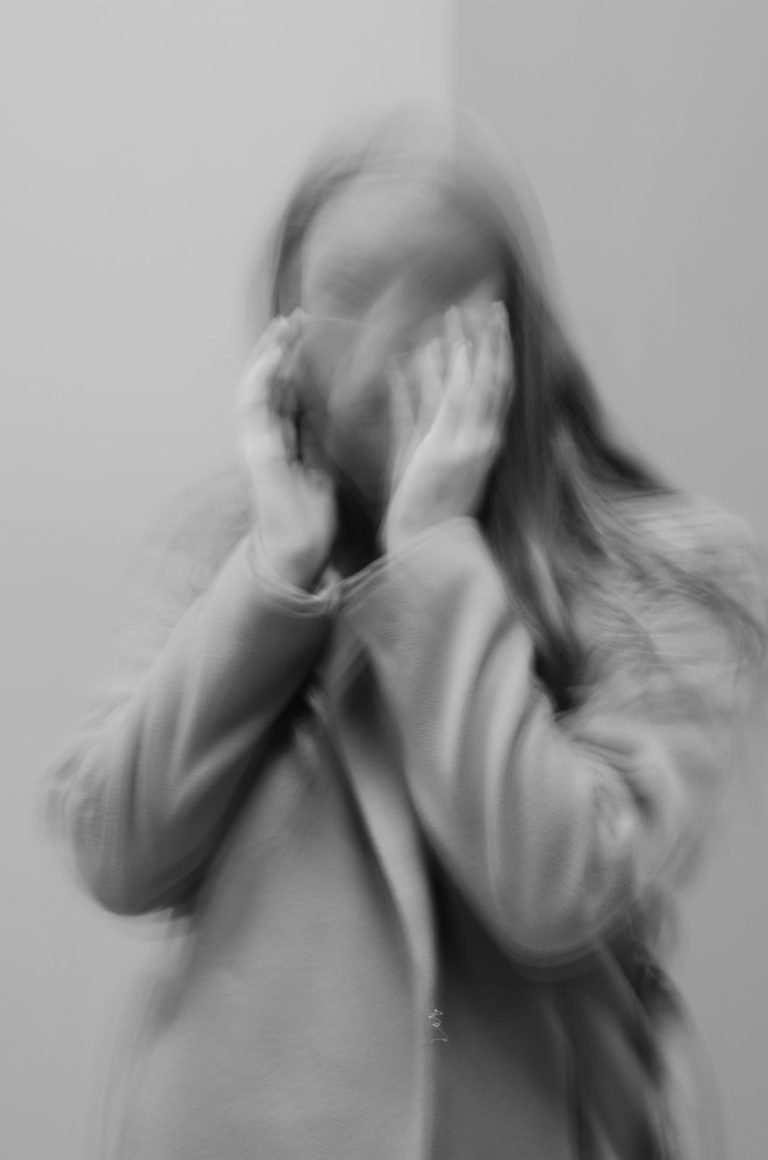 woman covering her face with her hand